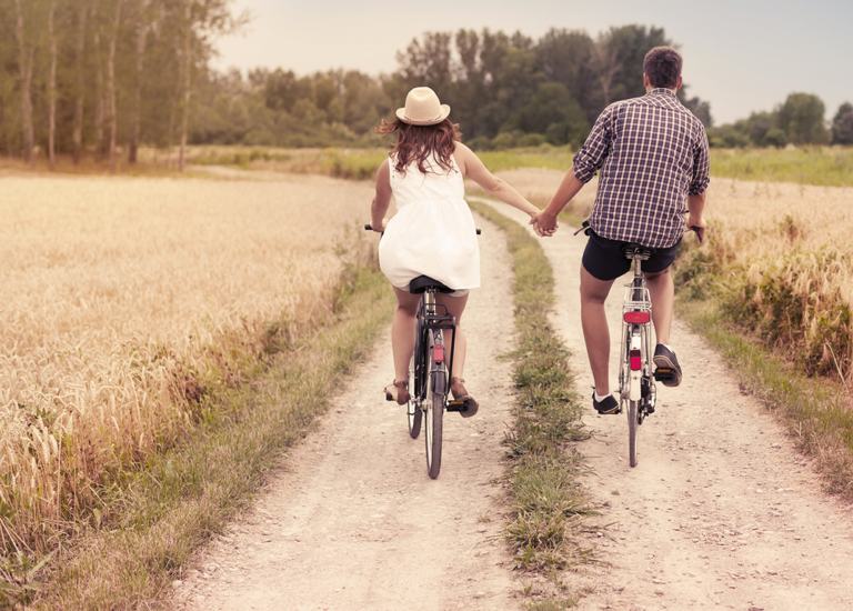 Cycling couple holding hands