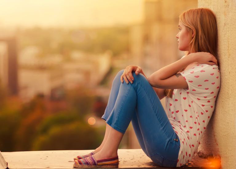 Girl sitting against a wall