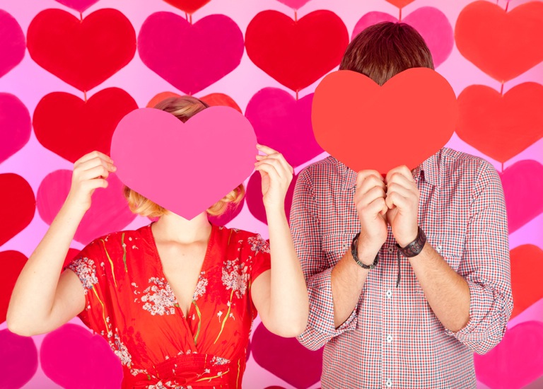 Couple with hearts covering face