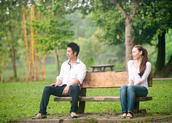 Asian couple sitting on a park bench