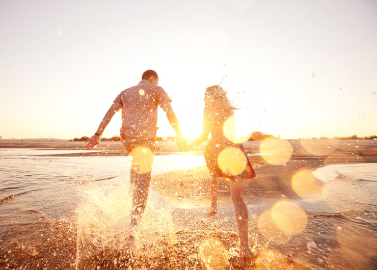 happy couple running on the beach