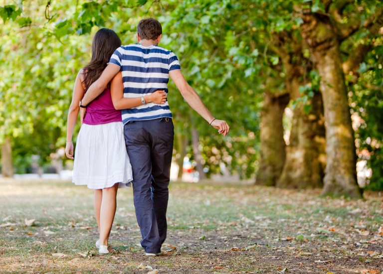 man and woman walking arm in arm