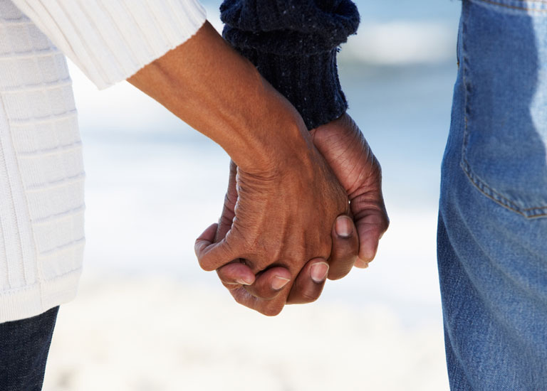 An older couple holding hands