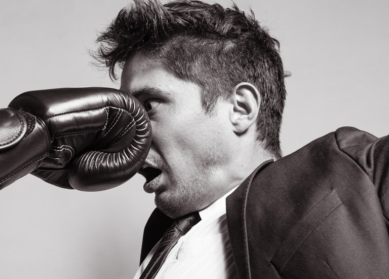 Man being punched in the face by a boxing glove