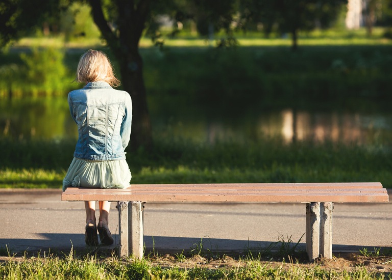 woman sitting alone on park bench