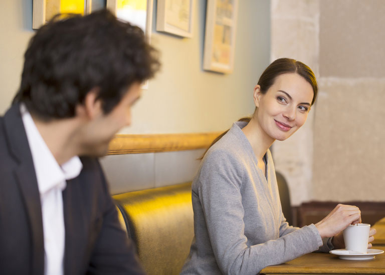 Man talking to a woman in a cafe