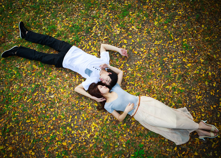 Young couple lying on leaves