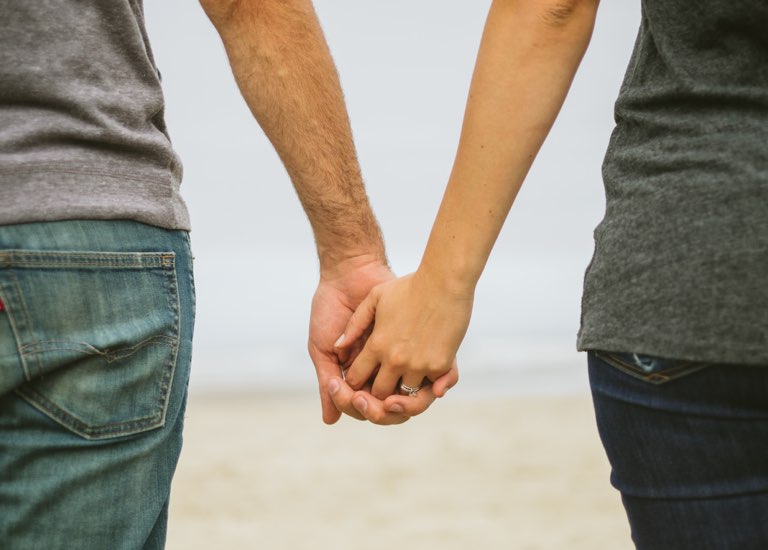 Engaged couple holding hands