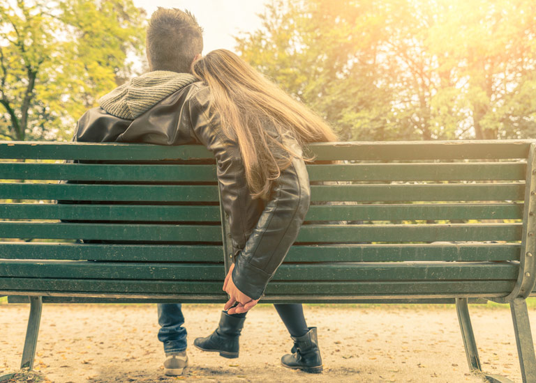 A couple sitting together on a bench