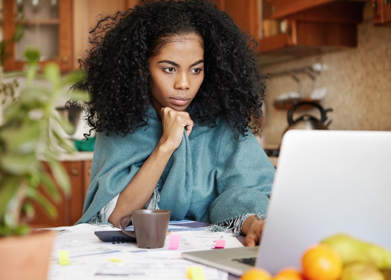 A woman looking inquisitively at a laptop