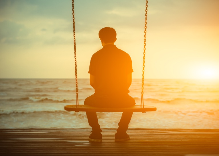 Man sitting on a swing alone