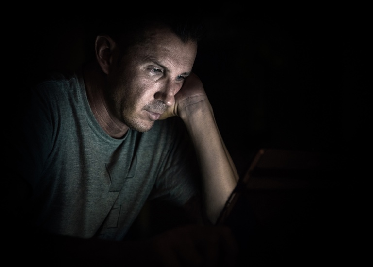 Man looking at a laptop in the dark