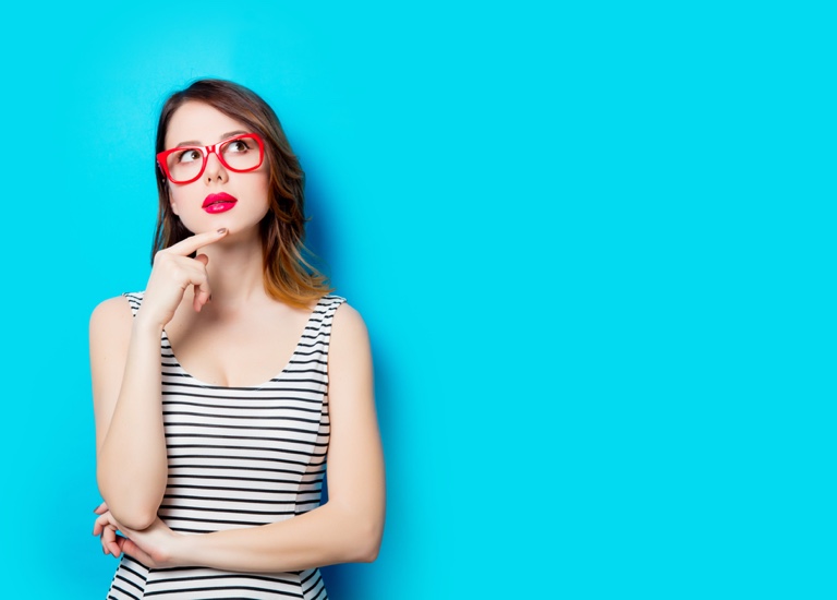 Woman on plain blue background thinking