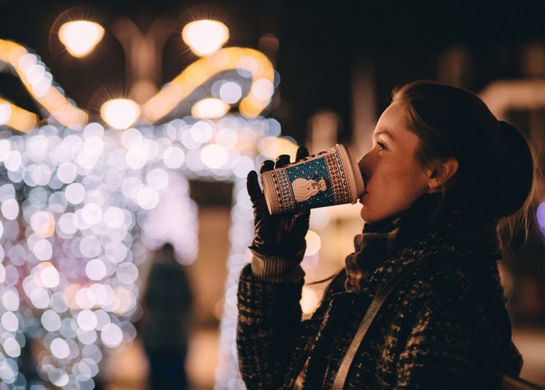 Woman drinking a hot drink with a Christmas theme