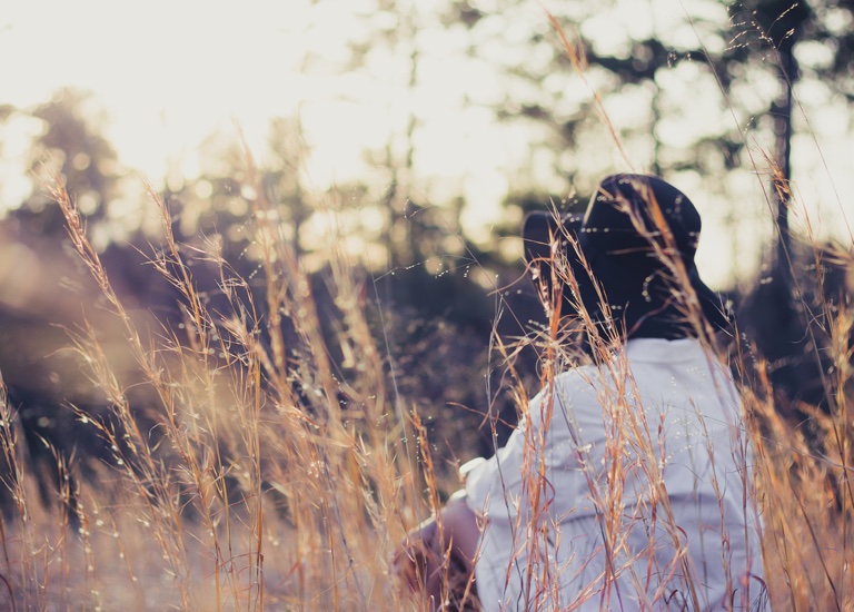 A woman sitting in long grass