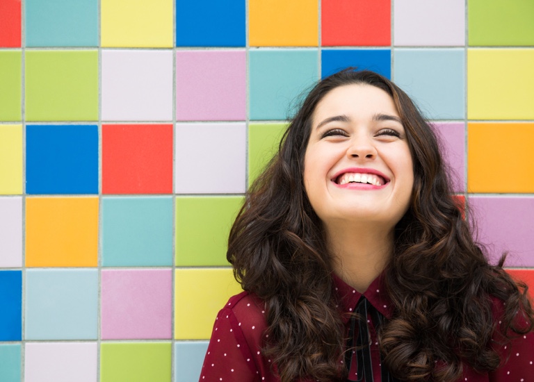 Smiling woman in front of colourful tiles