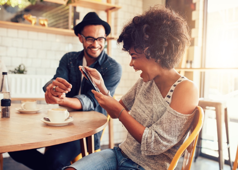 Couple smiling together looking at tablet