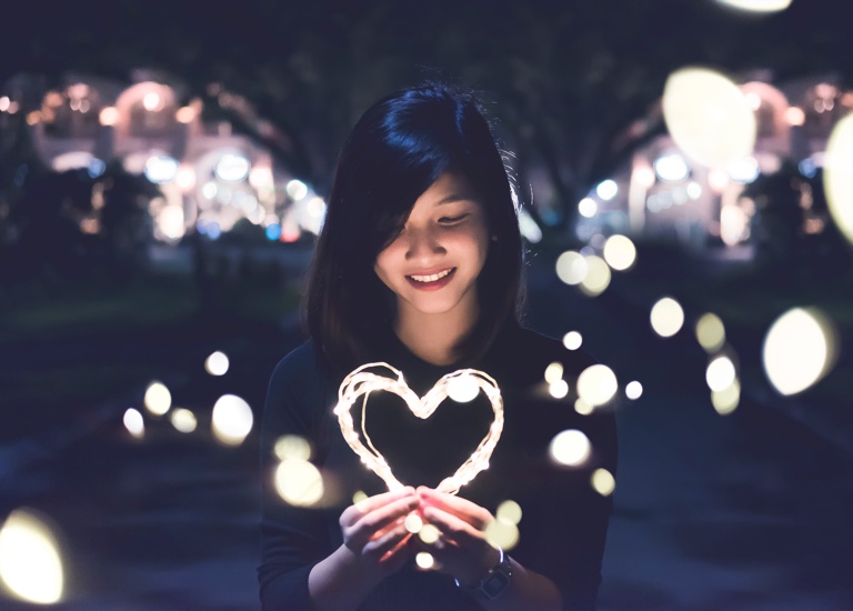 Woman looking at a heart shaped light