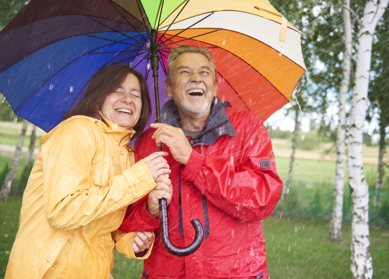 Smiling couple holding an umbrella