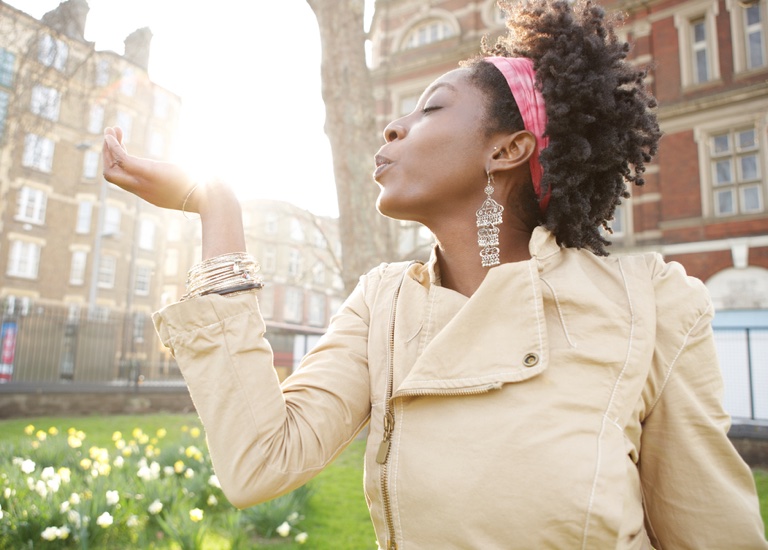 Young black woman holding the sun in her hand