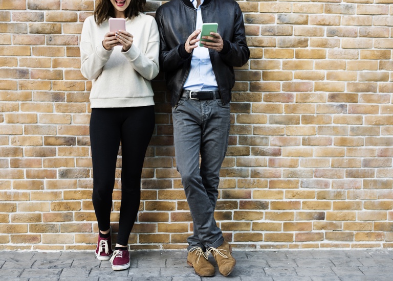 Two people messaging on their smartphones