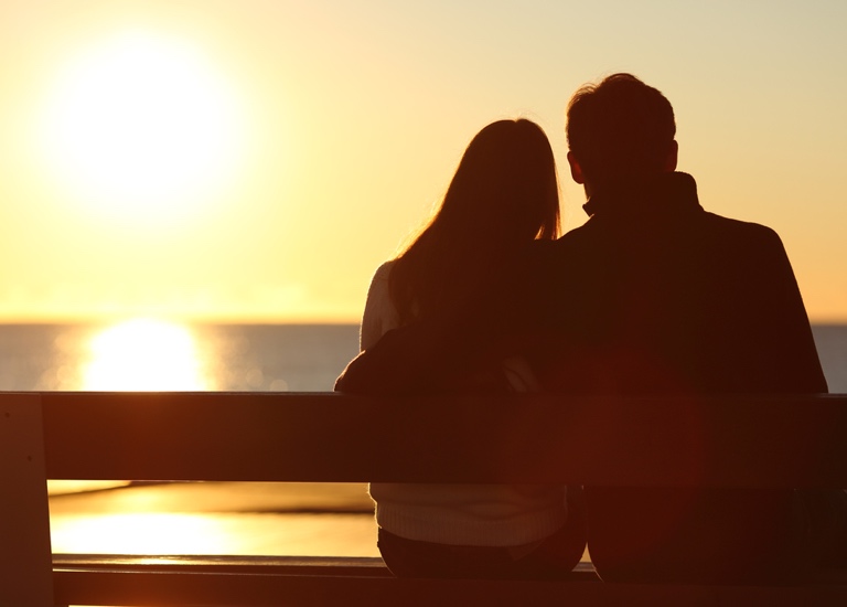 Back view of a couple silhouette hugging