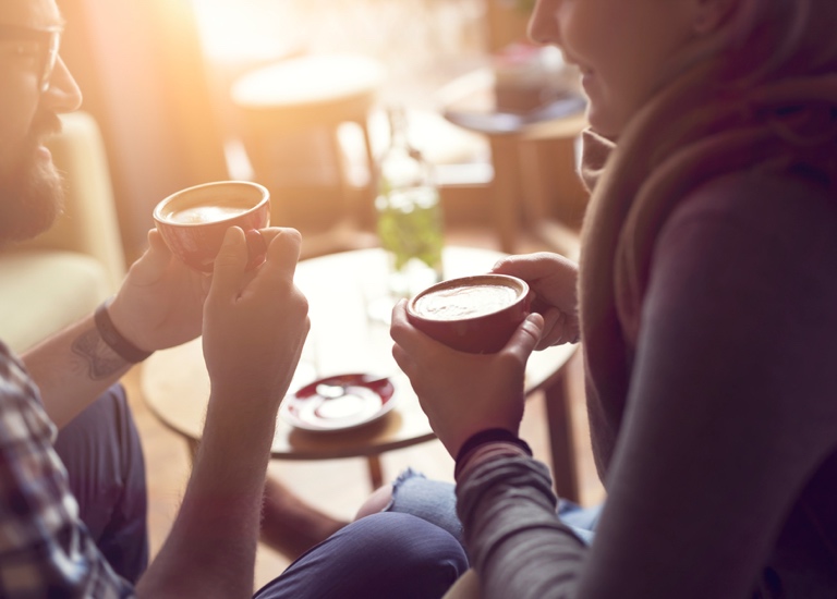 Two people share a coffee and a chat