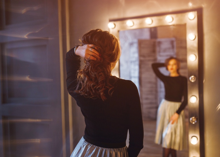Young woman looking in the mirror