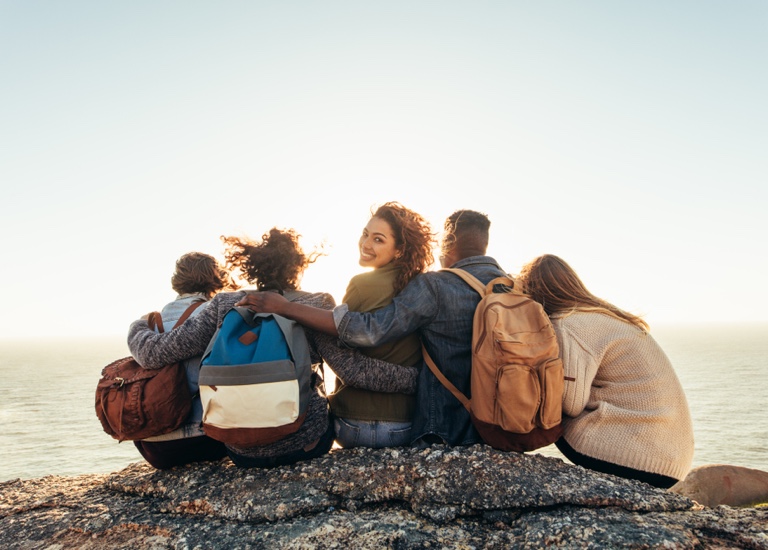 A group of friends huddled on a rock