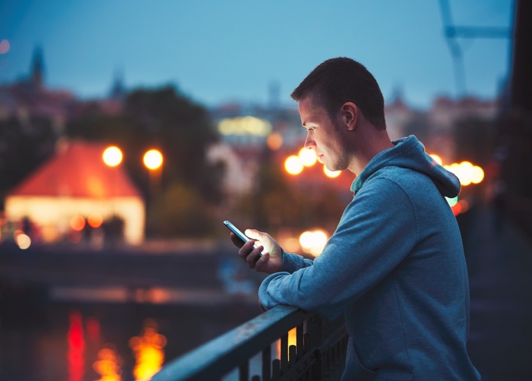 A man alone in the night city with a smartphone