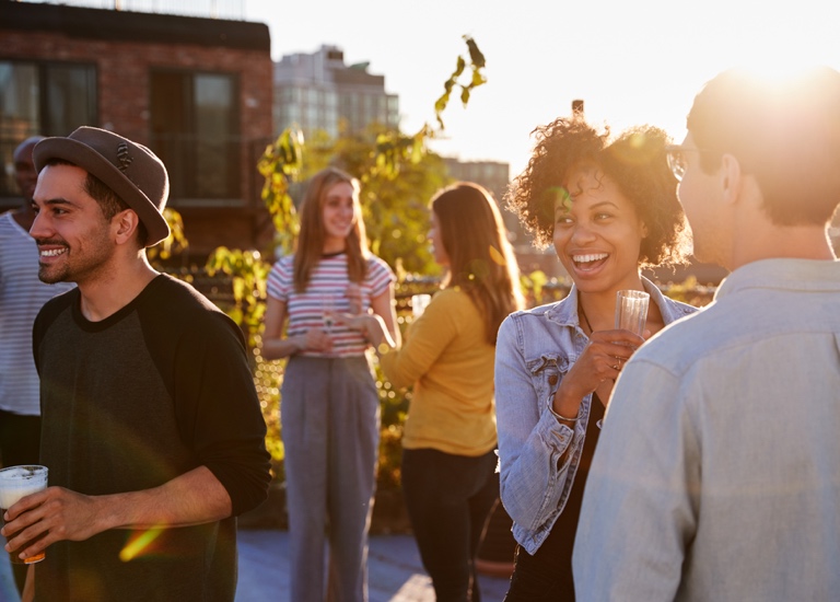 A group of people socialising on a rooftop bar