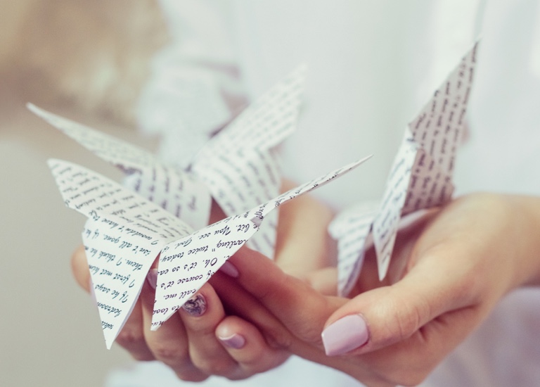 Close up of a woman holding an origami butterfly