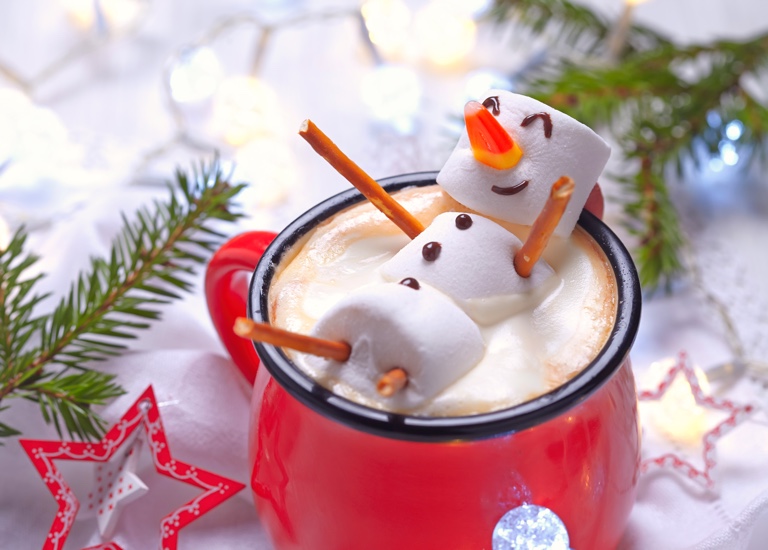 A happy marshmallow snowman in a mug of hot chocolate