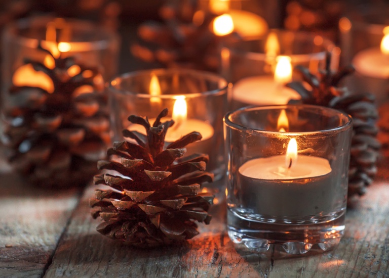 Tranquil, festive picture of a candle and a pine cone