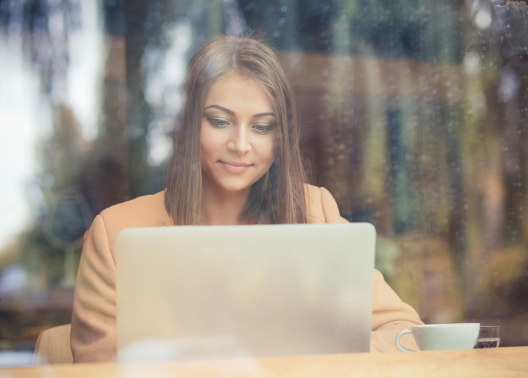 A young woman typing on a laptop