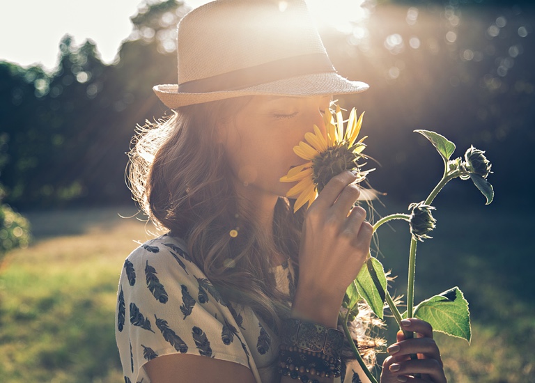 A woman smelling a sunflower