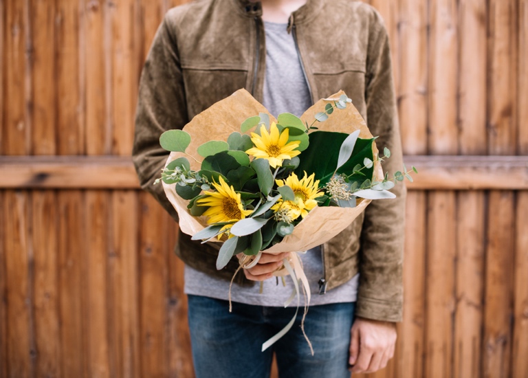 Man holding a bunch of flowers