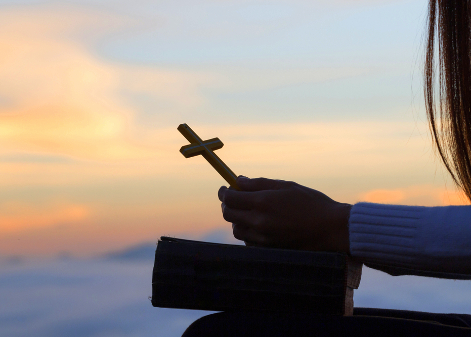 A woman holidng a cross and a Bible