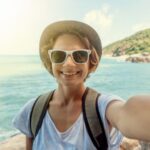 Happy pretty woman doing selfie on tropical beach