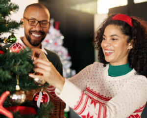 Man and woman decorating a Christmas tree - Christian Connection blog - 6 joyful Christmas date ideas to celebrate the season