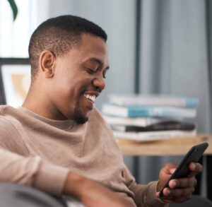 Man using smartphone and smiling - How to use the 'Discover' filters on Christian Connection for effective searching - Christian Connection blog
