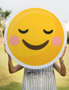 Woman holding smile emoji 3 important ways to manage your emotions while dating - Christian Connection blog