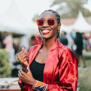 Happy woman in red jacket and glasses at festival - 6 simple ways to connect at festivals - Christian Connection blog