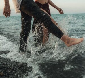 Man and woman splashing in the sea - 9 water date ideas to refresh your time together - Christian Connection blog